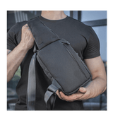 Person bærer M-Tac Sling Pistoltaske Elite Hex, komfortabel og holdbar taske med justerbar skulderrem og slidstærkt materiale.