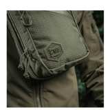M-Tac Sling Pistoltaske Elite Hex på en person iført jakke, fremstillet i slidstærkt Cordura 1000D materiale med justerbar rem.