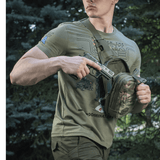 Mand bærer M-Tac Sling Pistoltaske Elite Hex med en skjult pistol i skoven.