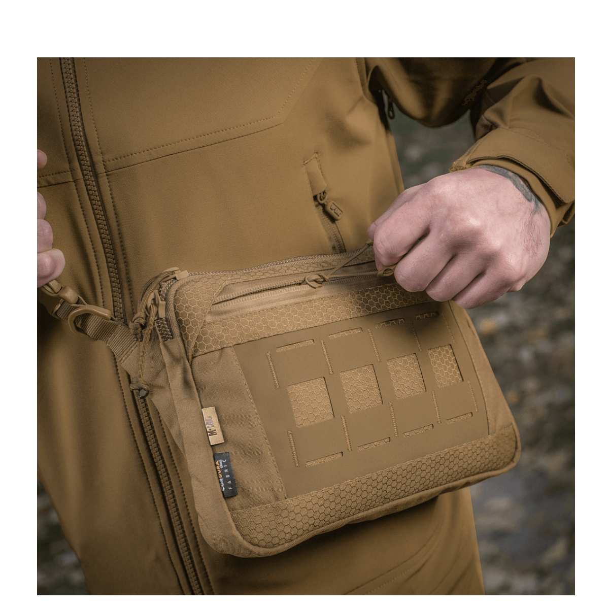 M-Tac Admin Taske Elite i slidstærkt Cordura-materiale med YKK-lynlåse, set på en person i udendørs omgivelser.
