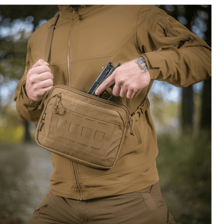 M-Tac Admin Taske Elite fremstillet af Cordura, bæres udendørs af person iført taktisk tøj, viser taskens størrelse og design.