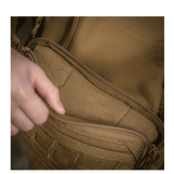 Person åbner lomme på M-Tac Admin Taske Elite lavet af slidstærkt Cordura materiale med YKK lynlåse.