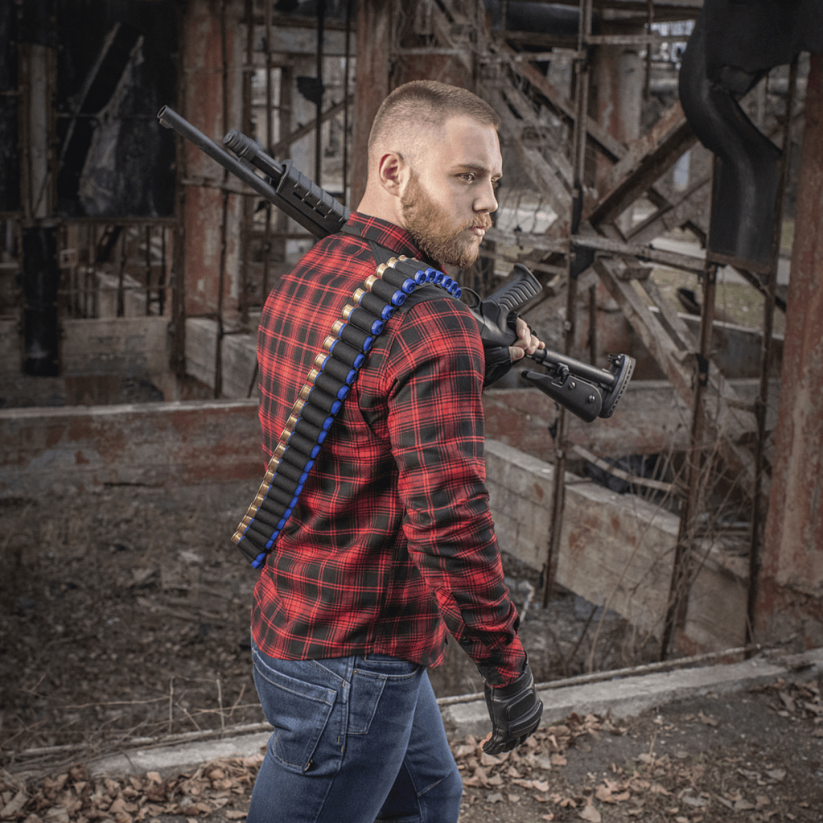 Mand iført M-Tac Bandolier Elite med patroner, klar til jagt eller skydesport, stående i et industrielt miljø.