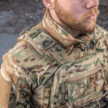 Mand iført M-Tac Skulderpude til Plate Carrier Cuirass QRS i slidsikkert Cordura med velcro fastgørelse ved camouflageudstyr.