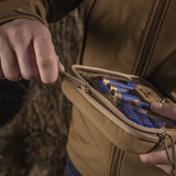 Person åbner M-Tac Utility Organizer Slim Elite i Cordura 500D med synlige genstande gennem PVC-folie.