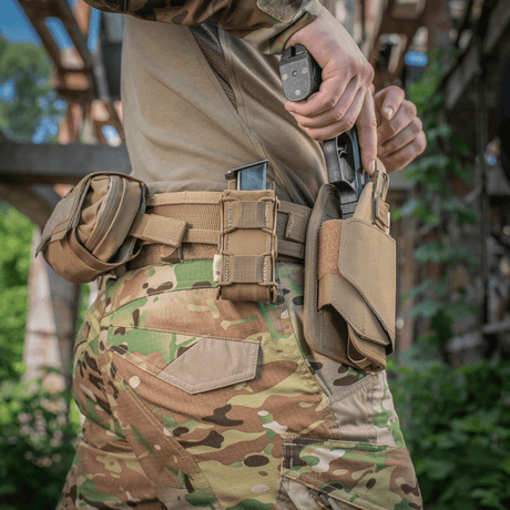 Soldat med M-Tac Pistolmagasinlomme Kolchan i camouflagedragt, der trækker et magasin fra højkvalitets Cordura 1000D taske. Sikker opbevaring og hurtig adgang.