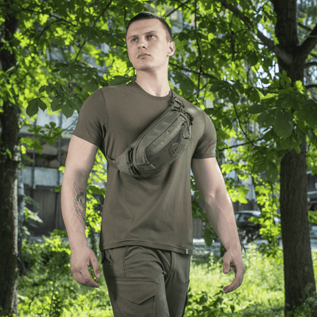 M-Tac Bæltetaske Elite Hex bæres af person i naturmiljø. Taske lavet af Cordura 500D med YKK lynlåse og Woojin spænder.