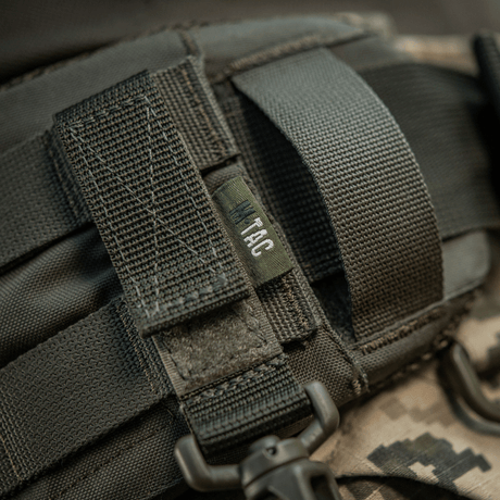 M-Tac Karabinhage Tilbehør fastgjort til MOLLE-system med Velcro-rem, perfekt til taktisk udstyr, letvægt og kompakt design.