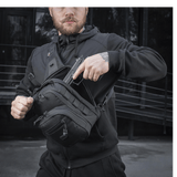 Mand iført M-Tac Cross Taske Slim Elite Hex i sort med Cordura materialer, lynlåse og spænder fra YKK og Woojin, udendørs miljø