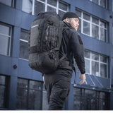 Mand bærer M-Tac Rygsæk Large Elite Hex Gen. IV i sort, ergonomisk designet til funktionalitet og holdbarhed, set i urbant miljø.