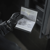 Person med handsker holder et M‑Tac Pascover, der beskytter et pas mod slid, med plads til plastkort og stilfuldt logo. Dimensioner: 13,5 x 10 cm.