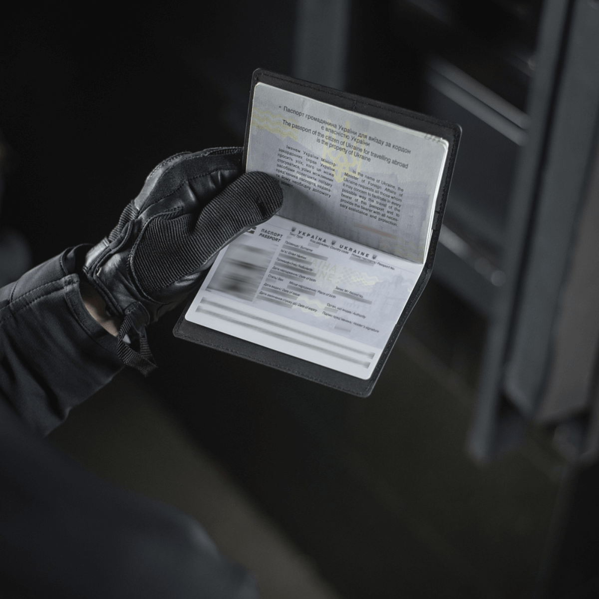 Person med handsker holder et M‑Tac Pascover, der beskytter et pas mod slid, med plads til plastkort og stilfuldt logo. Dimensioner: 13,5 x 10 cm.