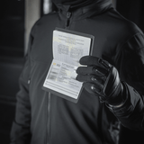 Person med M‑Tac Pascover holder et pas, beskytter mod slid og skader, moderne polymer, stilfuldt design, ideel til rejser.