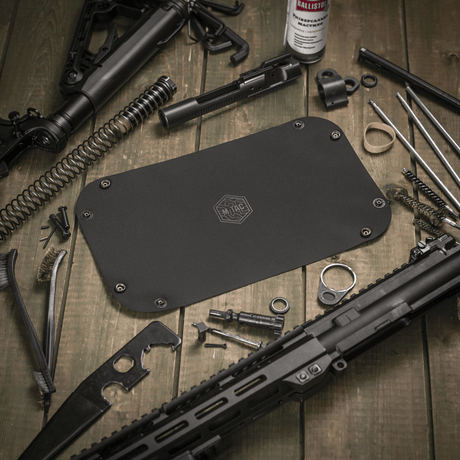 M‑Tac Field Vedligeholdelsesbakke 18x30 cm brugt til våbenvedligeholdelse, omgivet af værktøj og dele, polymerkomposit materiale.