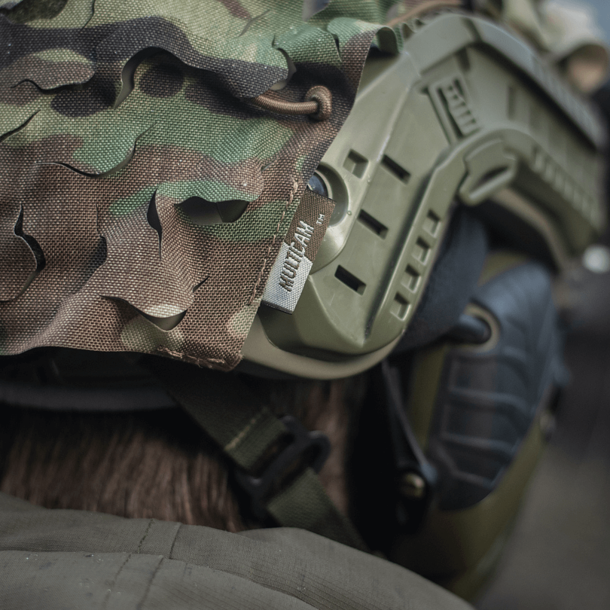 M-Tac Vilha Hjelmcover FAST med multicam mønster, designet til camouflage og beskyttelse på ujævnt terræn; set tæt på.