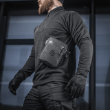 M-Tac Pocket Bag Elite HEX båret af en mand, ideel til kompakt opbevaring af EDC-udstyr med slidstærkt materiale og YKK lynlåse.
