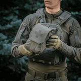 Person holder M‑Tac Medic Pouch Vertical Large Elite i slidstærkt Cordura, ideel til førstehjælpsudstyr og hurtig adgang.
