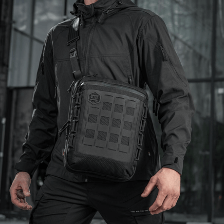 M-Tac Tablet Bag Laser Cut Hex bæres af en mand i sort jakke, robust og praktisk taske til EDC og skjult bæring.