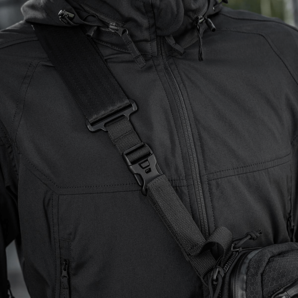 Nærbillede af sort M-Tac Tablet Bag Laser Cut Hex-skuldertaske på person, fremstillet i holdbart Cordura-materiale med justerbar strop.