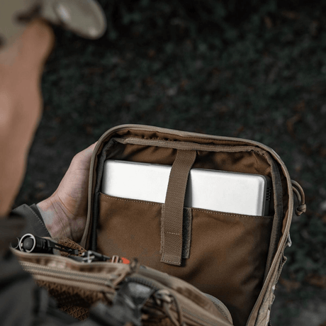 Person åbner M-Tac Tablet Bag Laser Cut Hex med indhold som tablet og dokumenter