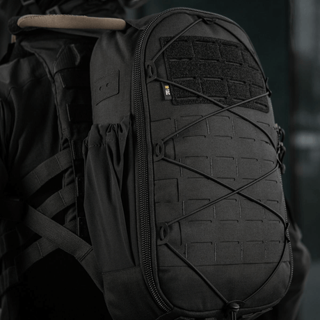 M-Tac STURM Elite Rygsæk med MOLLE Laser Cut design og Cordura materiale på en persons ryg, set fra siden.