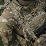Person i camouflageuniform med taktisk vest i nærbillede, viser MOLLE Laser Cut system, der bruges til M-Tac STURM Elite Rygsæk.