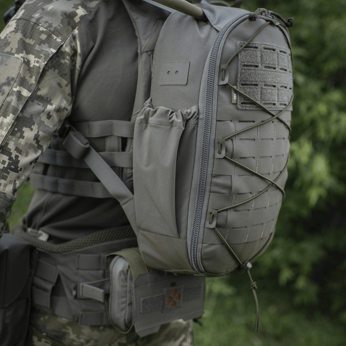 M-Tac STURM Elite Rygsæk i taktisk brug med MOLLE Laser Cut frontpanel og sidelommer, perfekt til kortvarige missioner og nødvendigt udstyr.