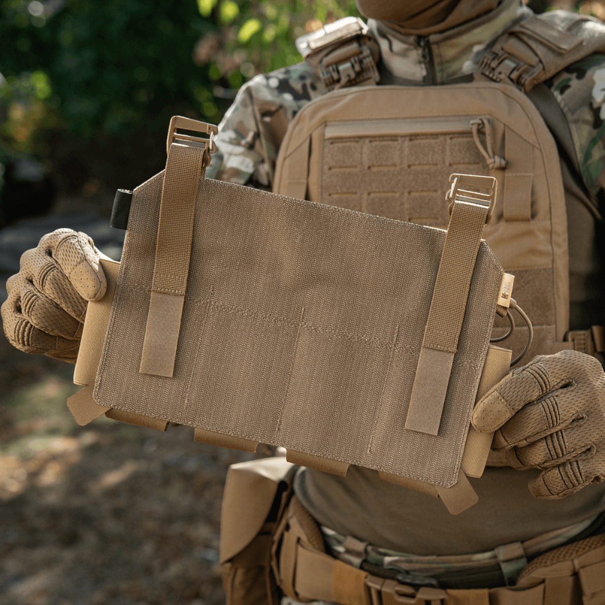 M-Tac Frontpanel til Plate Carrier Cuirass QRS til 4 Magasiner i brug, holdt af en soldat iført camouflageudstyr.