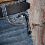 M-Tac Knife Lanyard Scandinavian i flettet paracord på en lommekniv i buksens lomme, stilfuldt og praktisk tilbehør.