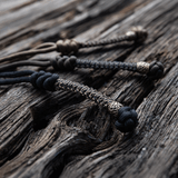 M-Tac Knife Lanyard Scandinavian flettet paracordstilføjelse til lommeknive på træoverflade, stilfuldt og praktisk tilbehør