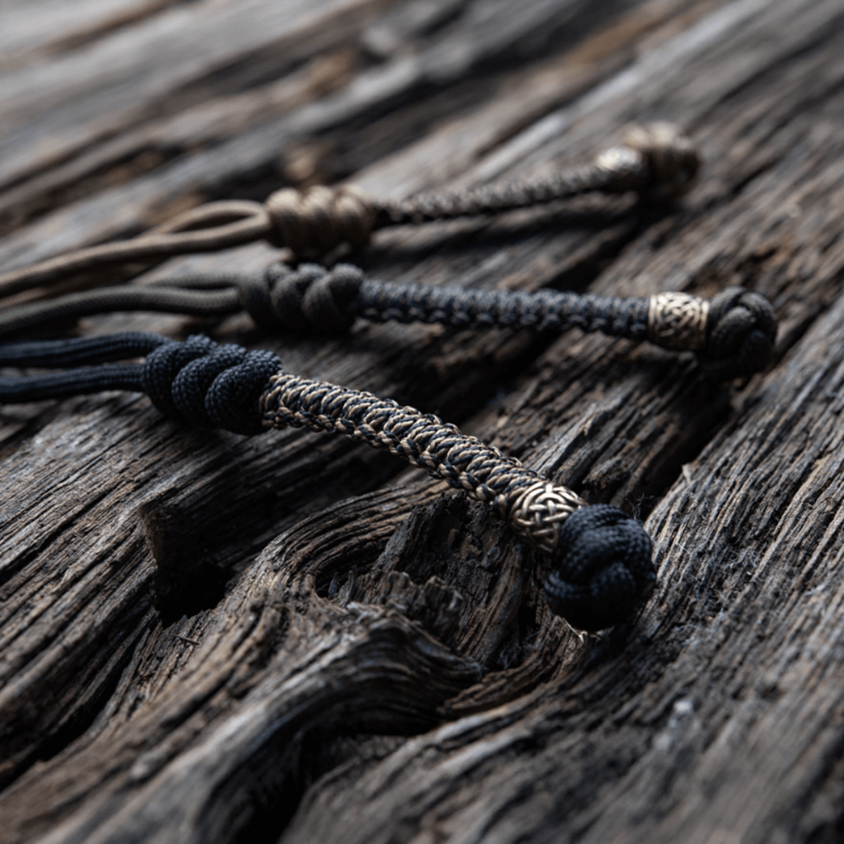 M-Tac Knife Lanyard Scandinavian flettet paracordstilføjelse til lommeknive på træoverflade, stilfuldt og praktisk tilbehør