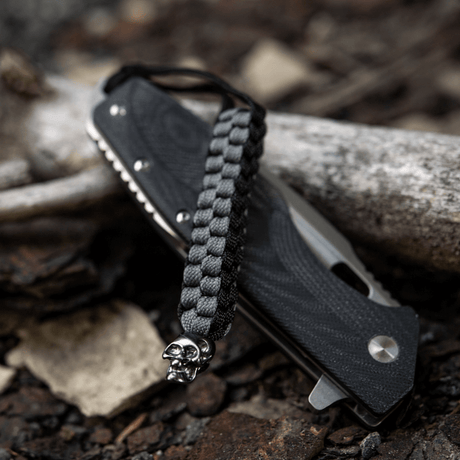 M-Tac Knife Lanyard Cuboid Skull med råt paracord design og dekorativ kranieperle, praktisk til knivhåndteringsforlængelse.