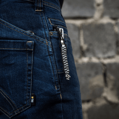 M-Tac Knife Lanyard Cuboid Skull fastgjort til jeans med paracord-flettet design og dekorativ kraniumperle.