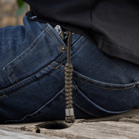 M-Tac Viper Lanyard Stainless Steel i jeanslomme, praktisk paracord til hurtig knivadgang, stilfuldt rustfrit stålperle design.