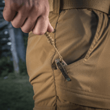 En person trækker hurtigt en kniv op af lommen ved hjælp af M-Tac Viper Lanyard Stainless Steel i flettet paracord med stålperle.