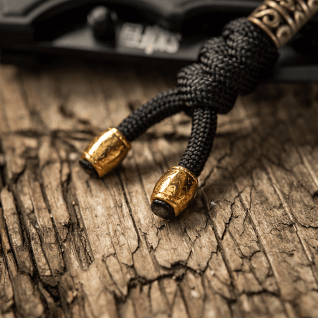 M-Tac Zeus Lanyard i flettet paracord-design, dekorativt og praktisk tilbehør med gyldne detaljer, ideel til kniv og udstyr.