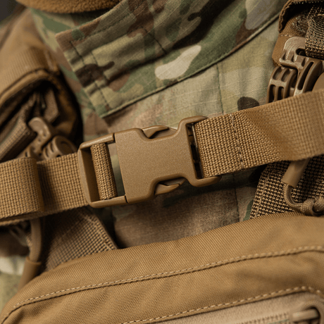 Nærbillede af M-Tac Rygsæk Sturm Elite Gen.II med robust spænde og camouflagebaggrund, ideel til taktiske aktiviteter.