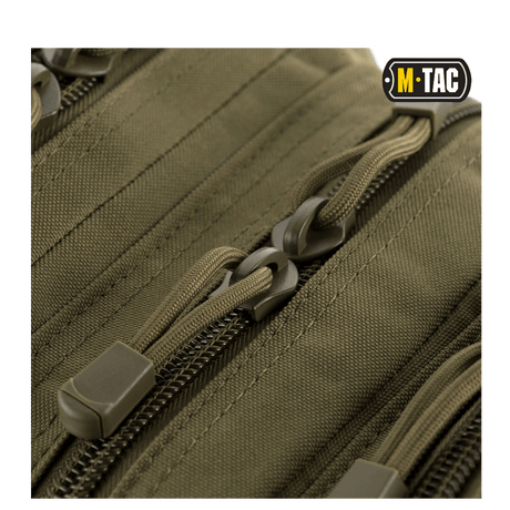 Nærbillede af lynlåse på M-Tac Assault Pack med MOLLE-system og polstrede skulderremme.