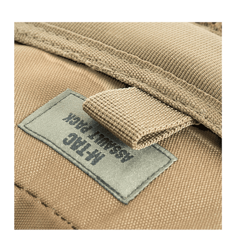M-Tac Assault Pack med MOLLE-system og polstrede skulderremme, nærbillede af etiket på den beige rygsæk.