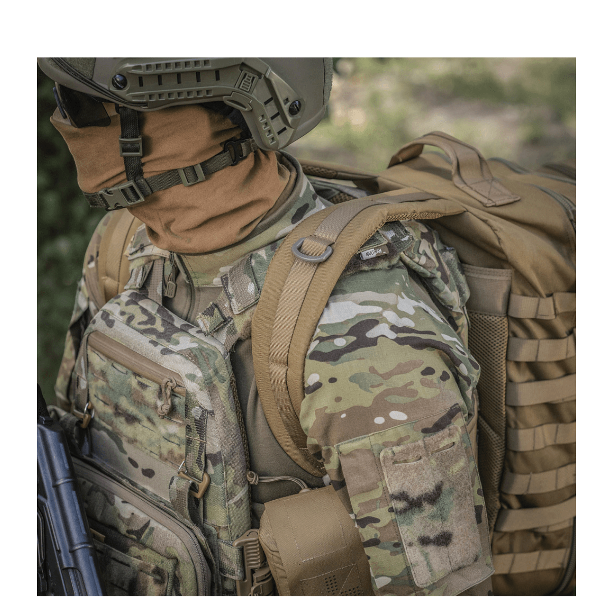 M-Tac Large Assault Pack Rygsæk med MOLLE-system og polstrede skulderremme set på en person i kamouflageudstyr.