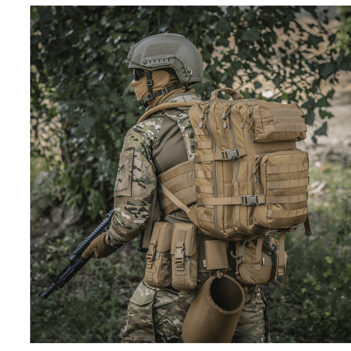 M-Tac Large Assault Pack Rygsæk med MOLLE-system, bæres af person i camouflageuniform under træer