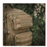M-Tac Large Assault Pack Rygsæk i taktisk design med MOLLE-system og ekstra lommer, set i tæt skovområde.