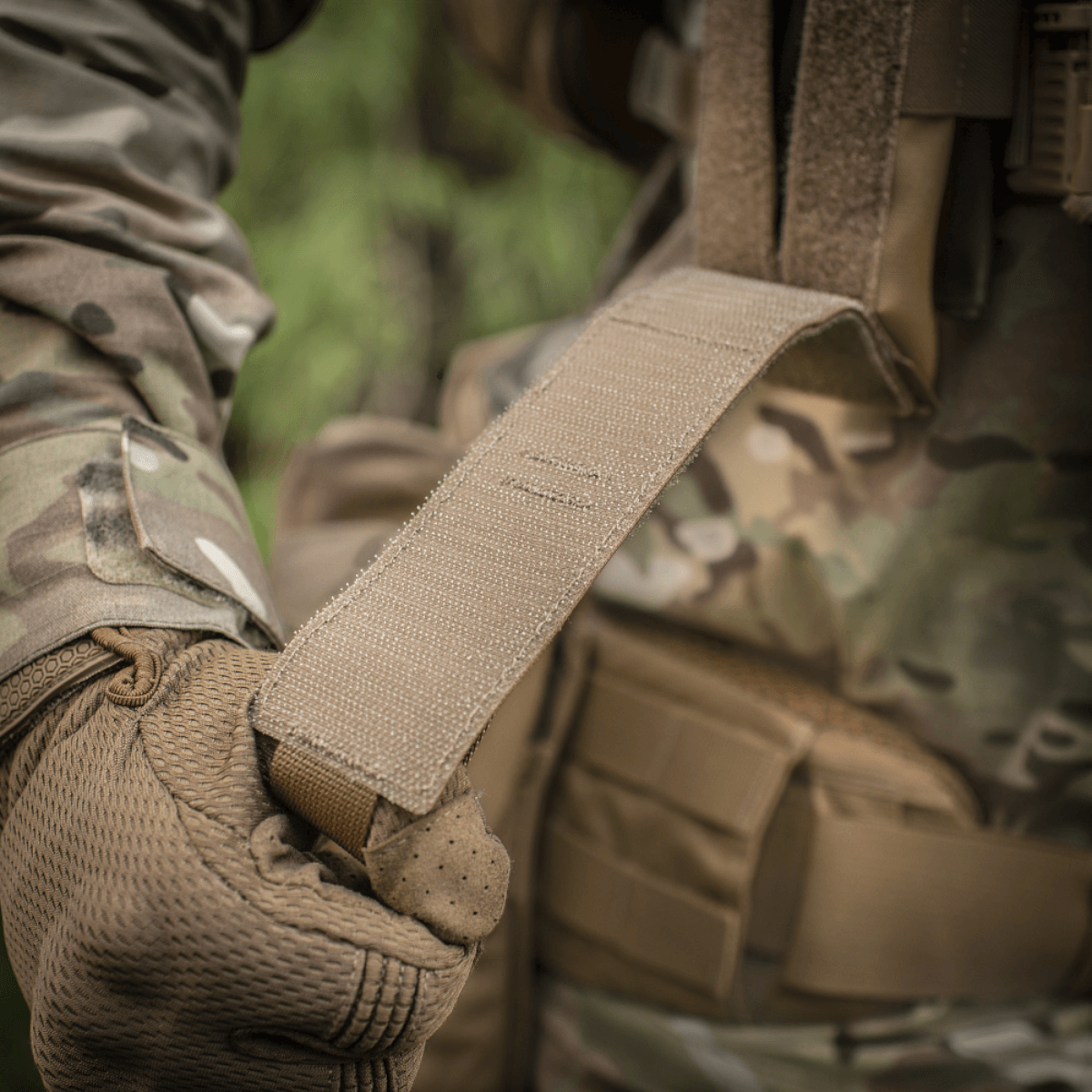 M-Tac Lomme til Tourniquet Closed i brug af person i militærlignende tøj, fokus på stærk rem og beskyttelse i felten.