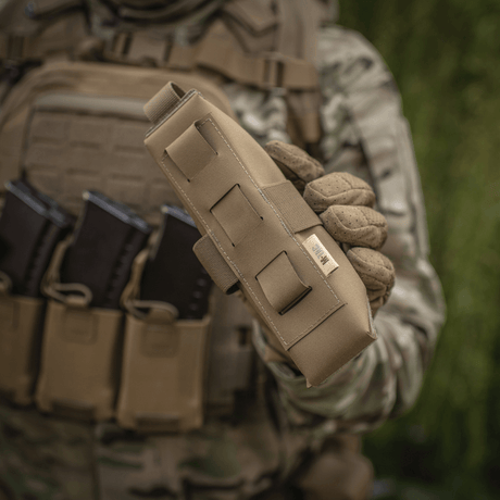 M-Tac Lomme til Tourniquet Closed holdt af person i militæruniform, perfekt til førstehjælp og beskyttelse af tourniquet.