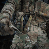 M-Tac Lomme til Tourniquet Closed fastgjort til militæruniform i felten, sikrer hurtig adgang til førstehjælpunder nødsituationer.