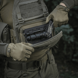Person åbner M-Tac Admin Pouch Large Elite med taktisk udstyr, fremstillet af slidstærkt Cordura 500D, velegnet til udendørs brug.