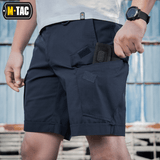 Mand iført M-Tac Shorts Aggressor Short med taktiske funktioner, ideel til varme dage, designet i elastisk polycotton flex rip-stop materiale