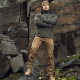 Mand iført M-Tac Norman Windblock Fleecejakke foran klippevæg, robust og stilfuld udendørs beklædning i naturen.