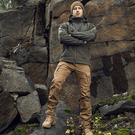 Mand iført M-Tac Norman Windblock Fleecejakke foran klippevæg, robust og stilfuld udendørs beklædning i naturen.