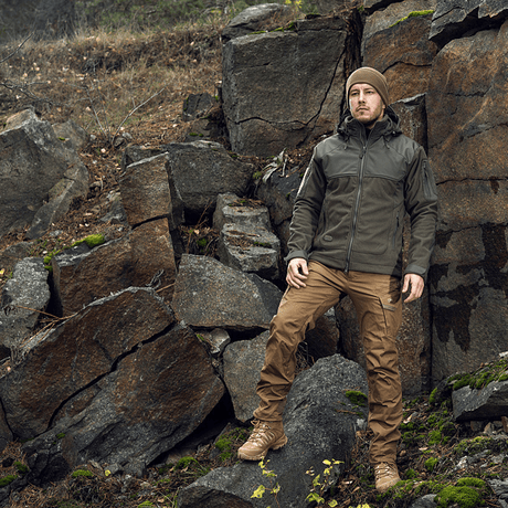 Mand iført M-Tac Norman Windblock Fleecejakke i naturen, designet til beskyttelse mod vind og kulde, ideel til lag-på-lag brug.